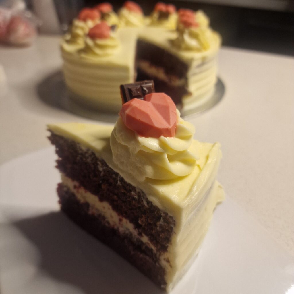 red velvet cake decorated with pink hearts made of white chocolate